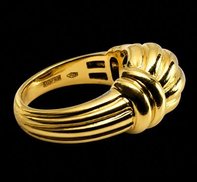 gros plan d'une bague en or sur fond noir