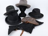 trois chapeaux et une ceinture sont posés sur une surface blanche