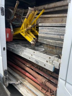 une camionnette blanche avec un tas de bois à l'arrière