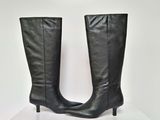 la paire de bottes en cuir noir repose sur une boîte blanche