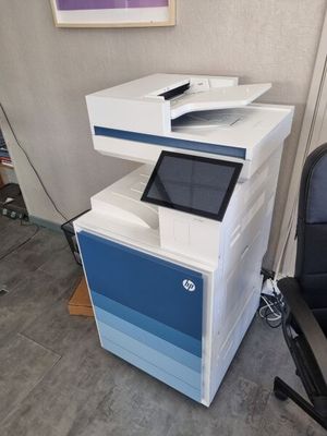 une imprimante posée sur un bureau, à côté d'une chaise