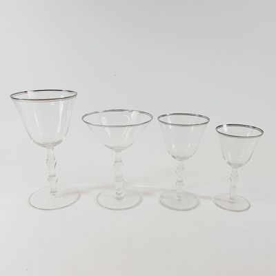 three wine glasses and a wine glass are sitting on a white surface