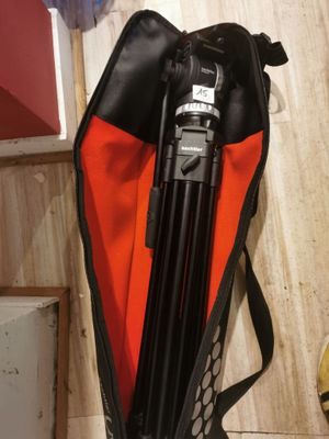 a camera and tripod in a bag on the floor