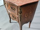 a small chest of drawers with a marble top