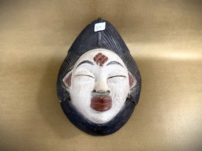a wooden mask hanging on the wall of a room