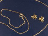 un ensemble composé d'un collier et de boucles d'oreilles en or sur fond bleu