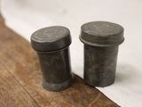 two salt and pepper shakers sitting on a wooden table