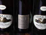 three bottles of wine are lined up on a wooden table