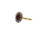 a close up of a gold ring with a red stone