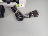 a box with a game controller and a charger on the table