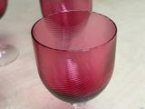 two wine glasses sitting on a table next to each other