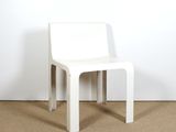 a white chair that is sitting in front of a white wall