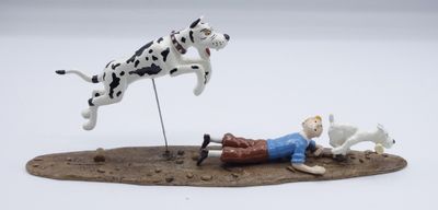 a figurine of a man laying on the ground with a dalmatian and a dog