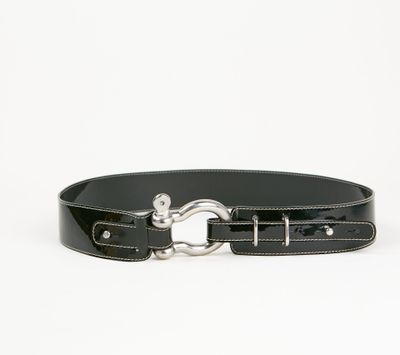 la ceinture est noire et est munie d'une boucle en métal