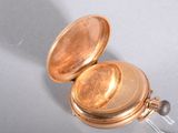 a close up of a gold pocket watch on a table