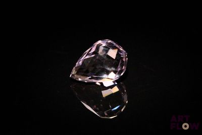 a close up of a purple diamond on a black surface