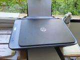 a laptop sitting on top of a desk next to a printer