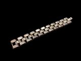 un gros plan d'un bracelet en métal sur fond noir