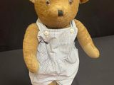 a teddy bear that is wearing a dress on a table