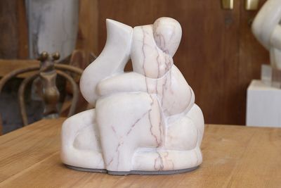 une sculpture en marbre représentant un homme et une femme assis sur un banc