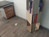 a desk with a book shelf in the corner of the room