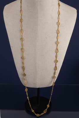 un collier en or sur un mannequin, sur fond bleu