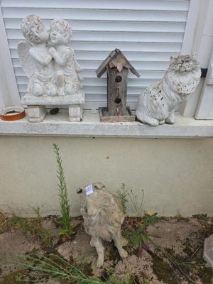 trois statues posées sur le rebord d'une fenêtre