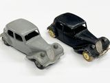 deux voitures jouets assises l'une à côté de l'autre sur une surface blanche