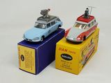 two toy cars sitting on top of boxes on a white surface