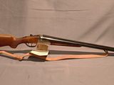 un vieux fusil avec un canon en bois et une fronde en cuir