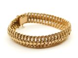 gros plan d'un bracelet en or sur fond blanc