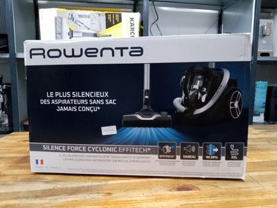 packaging of a black and white vacuum cleaner on a wooden table