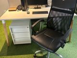a desk with a chair and a computer on it