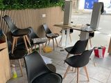 de nombreuses chaises et tables dans une pièce où des plantes sont accrochées au mur