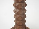 a wooden candle holder with a candle on top of it