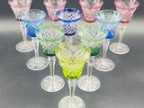 six different colored glass wine glasses are arranged in a circle