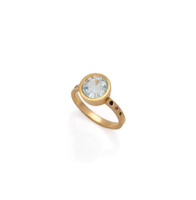 a gold ring with a blue topaz stone and a black diamond