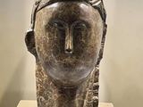 sculpture of a woman ' s head on a pedestal in a museum