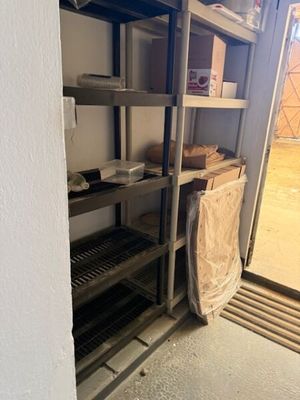 une pièce avec des étagères et une porte sur laquelle est accroché un sac