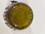 a silver ring with a green liquid inside of it