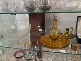 une étagère en verre sur laquelle sont posés de nombreux objets en verre