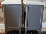 two gray cabinets sitting next to each other on a rug