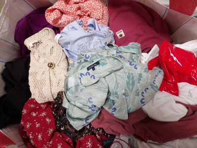 a pile of clothes in a basket on the floor