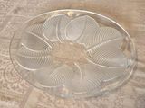 une assiette en verre transparent posée sur une table et ornée d'un motif