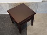 a small table with a brown top sitting on the floor