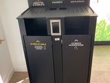 two black trash bins in the corner of a room
