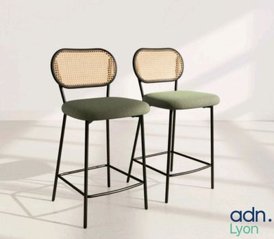 une paire de tabourets de bar en métal noir avec des assises rembourrées vertes