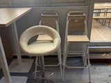three stools and a table in the corner of a room