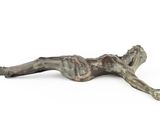 bronze sculpture of a woman laying on her back on a white surface
