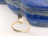 une image représentant une bague en or sertie de deux diamants noirs et blancs